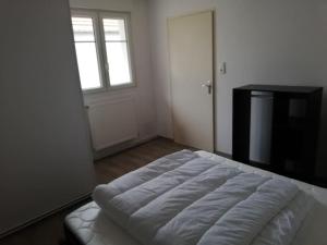 łóżko w pokoju z oknem i drzwiami w obiekcie L'appart des Sotrés w mieście Saint-Dié