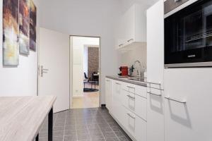 una cucina con armadi bianchi e ripiano in legno di DR Apartments Boxhagener Kiez a Berlino