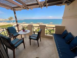 eine Terrasse mit Tisch und Stühlen sowie Strand in der Unterkunft Amazing Beachfront townhouse chalet Ain Sokhna LaVista 1 in Ain Suchna