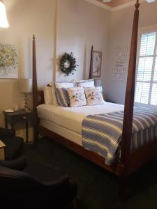 een slaapkamer met een bed met een houten frame bij Pecan Tree Inn in Beaufort