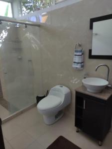 a bathroom with a toilet and a sink and a shower at Condominio Villa Esperanza in Flandes