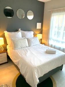 a bedroom with a large bed with white sheets and pillows at Homey 2-bedroom apartment & loft space in Sandton