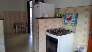 a kitchen with a stove and a white refrigerator at Hostel Meu Cantinho Caxambu Mg in Caxambu
