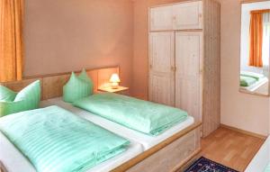 een slaapkamer met een bed met groene kussens bij Nice Home In Eichigt-ot Sssebach With Kitchen in Eichigt