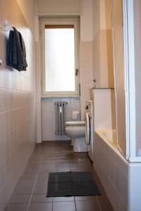 baño con aseo, ventana y lavamanos en Casa Manolo Corsico Navigli Suite Apartment Milan en Corsico