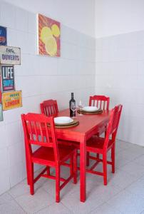 una mesa roja con cuatro sillas rojas alrededor en Casa Manolo Corsico Navigli Suite Apartment Milan en Corsico