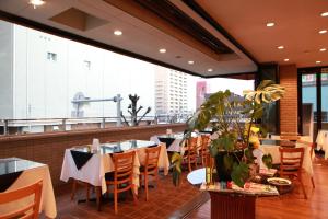 a restaurant with tables and chairs and a large window at Hotel Aria in Numazu
