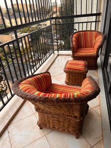 - deux chaises en osier assises sur un balcon dans l'établissement Crestpark 3br furnished apt, à Nairobi