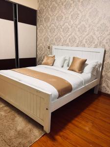 - une chambre avec un grand lit blanc et des oreillers dans l'établissement Crestpark 3br furnished apt, à Nairobi
