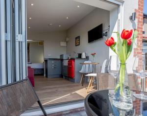 a vase of red roses sitting on a glass table at The View at 52, Whitby in Whitby