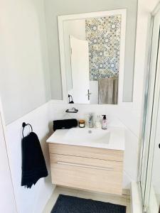a bathroom with a sink and a mirror at Homey 2-bedroom apartment & loft space in Sandton
