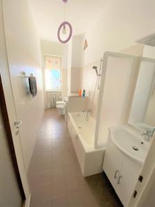 baño blanco con lavabo, bañera y aseo en Casa Manolo Corsico Navigli Suite Apartment Milan en Corsico