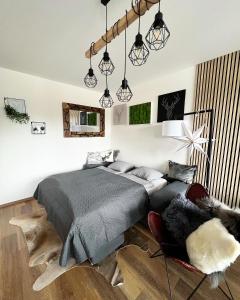 1 dormitorio con cama, silla y luces en U jelena Harrachov - apartmán u lesa s garáží, en Harrachov