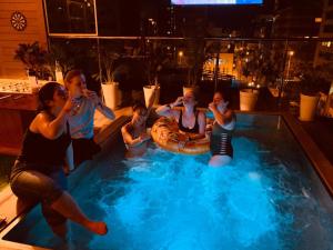 un grupo de mujeres sentadas en una piscina en Alpes Lima Kennedy Hostel en Lima
