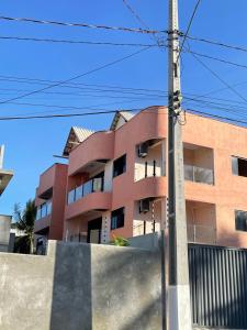 un bâtiment avec une clôture devant lui dans l'établissement Sol de Pirangi, à Parnamirim