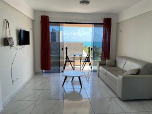 a living room with a couch and a table at Sol de Pirangi in Parnamirim