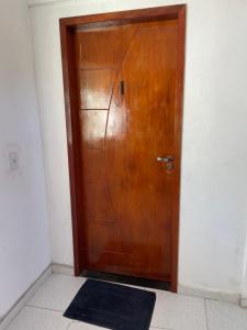 a wooden door in a room with a black rug at Sol de Pirangi in Parnamirim