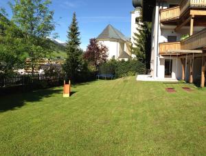 ein großer Hof mit einem Zaun und einem Gebäude in der Unterkunft Haus Willibald in Saalbach-Hinterglemm