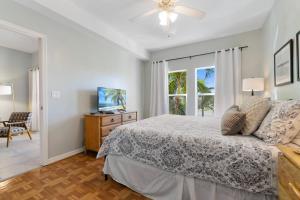 a bedroom with a bed and a tv and a window at Collier Condo #202 in Marco Island