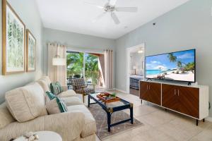 a living room with a couch and a flat screen tv at Collier Condo #202 in Marco Island