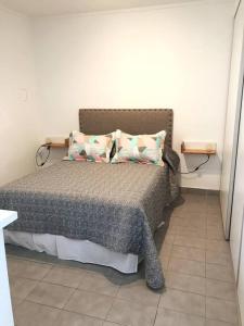 1 dormitorio con 1 cama con 2 almohadas en Monoambiente céntrico en Tandil