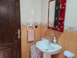 a bathroom with a sink and a mirror at Restaurante Cafe El Balcon in Beni Enzar