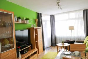 salon z telewizorem i zieloną ścianą w obiekcie Apartment Peter - Familienurlaub mit Indoorpool w mieście Schluchsee