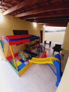 - une salle de jeux pour enfants avec une maison gonflable et une aire de jeux dans l'établissement Chácara Helenna Colonetti, à Lindóia