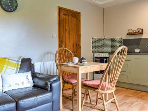 sala de estar con mesa, sillas y sofá en Little Fern en Sourton