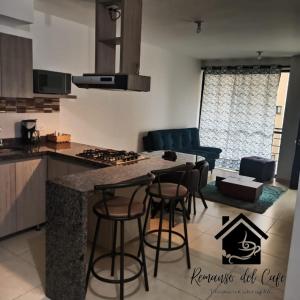 eine Küche und ein Wohnzimmer mit einem Tisch und Stühlen in der Unterkunft Remanso del café in La Tebaida
