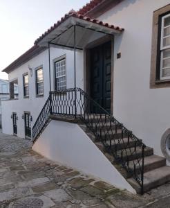 un edificio blanco con una escalera que conduce a una puerta en Casa de Santa Ana da Beira, en Seia