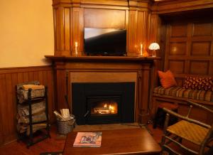 a living room with a fireplace with a tv above it at Adirondack Mountain View Retreat in Elizabethtown