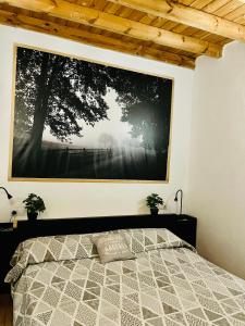 a bedroom with a large picture hanging above a bed at Dakota’s house in Las Lagunas