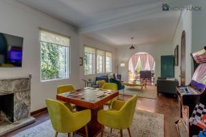 een woonkamer met een tafel en gele stoelen bij Refurbished Mansion with Garden & Patio in Las Lomas - Monte Blanco in Mexico-Stad
