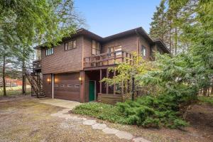 a large wooden house with a garage in the woods at Lakefront House by Michigan Waterfront Luxury Properties in Norton Shores