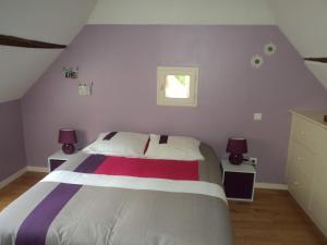 CarennacにあるGîte des Cardonnièresの紫の壁のベッドルーム1室(大型ベッド1台付)