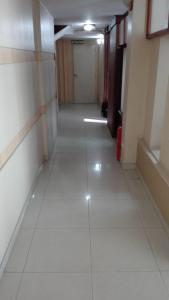 an empty hallway with white tile floors and a door at Alojamiento Avellaneda in Rosario