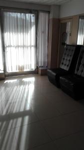 uma sala de estar com um sofá e uma grande janela em Alojamiento Avellaneda em Rosário