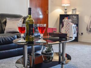 a table with two glasses and a bottle of wine at Creel Cottage in Auchmithie