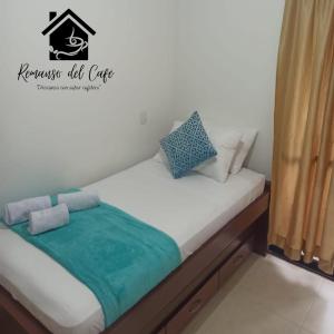ein kleines Bett mit einer grünen Decke drauf in der Unterkunft Remanso del café in La Tebaida