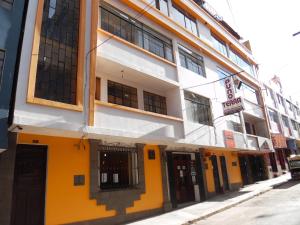 een geel en wit gebouw aan de straatkant bij Hotel Puno Terra in Puno