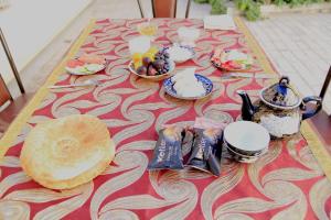 a table with a table cloth with food on it at Soliha&Yulduz Guesthouse in Bukhara