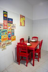 ein roter Esstisch mit roten Stühlen und Schildern in der Unterkunft Casa Manolo Corsico Navigli Suite Apartment Milan in Corsico