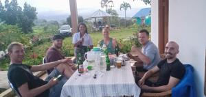 a group of people sitting around a table at Hobbit Hill in Ruteng