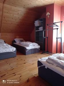 3 camas num quarto com paredes e pisos em madeira em Domek Miętowy Jodłów okolice Sławy całoroczny em Jodlow