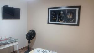 a room with a fan and a picture on the wall at Hostal Avanza in Cali