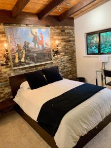 a bedroom with a large bed with a painting on the wall at [RARE] Buckhead Mid-century Masterpiece! in Atlanta