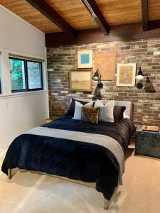 a bedroom with a large bed with a brick wall at [RARE] Buckhead Mid-century Masterpiece! in Atlanta