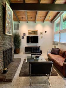 a living room with a couch and a tv at [RARE] Buckhead Mid-century Masterpiece! in Atlanta