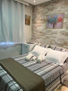 een slaapkamer met een bed met 2 kussens erop bij STUDIOS CORACAO EUCARISTICO in Belo Horizonte